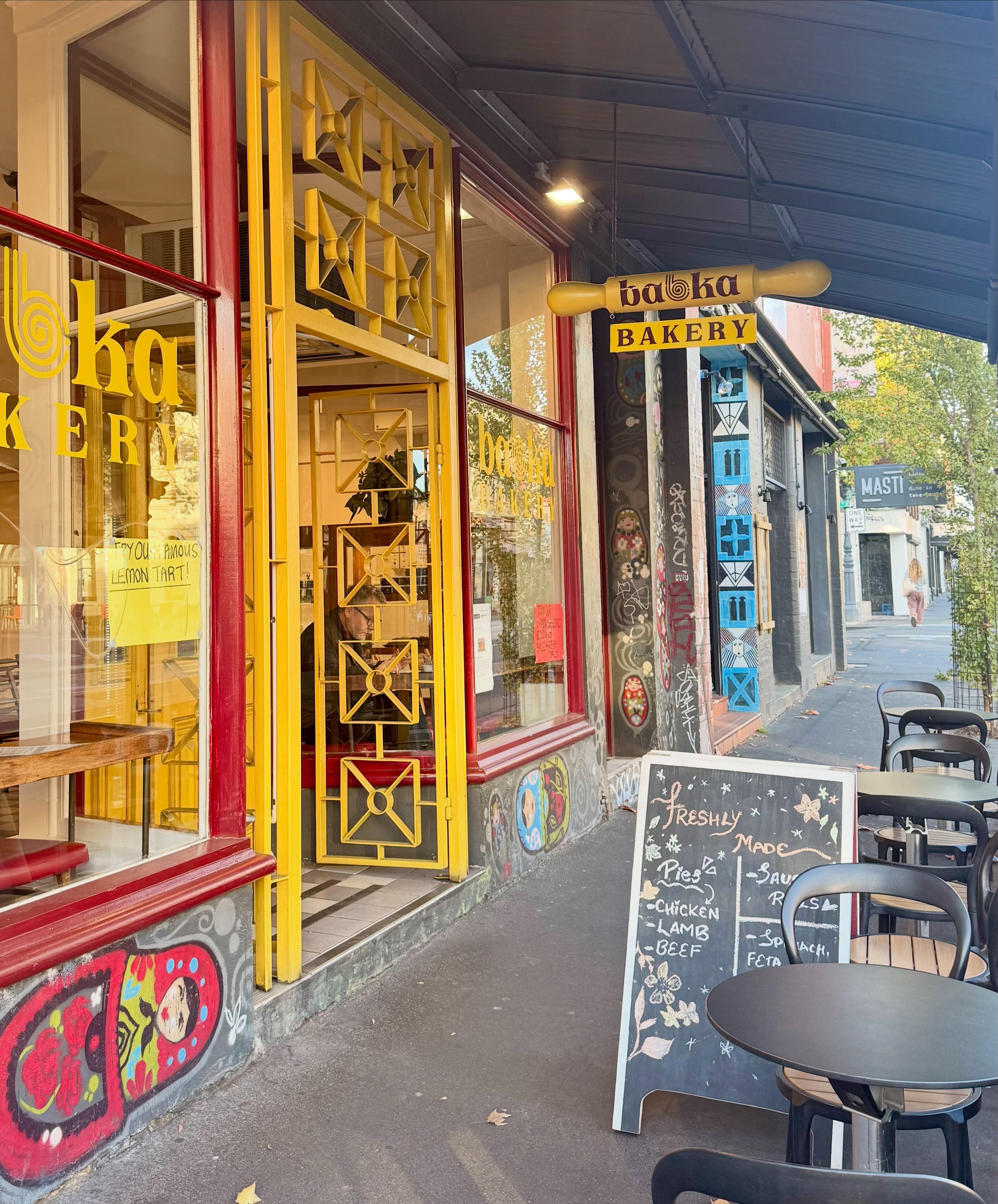 The colourful Babka Bakery storefront on Brunswick Street in Fitzroy, with outdoor cafe seating and a chalkboard menu